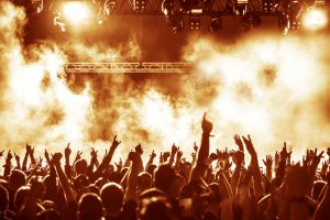 silhouettes of concert crowd in front of bright stage lights